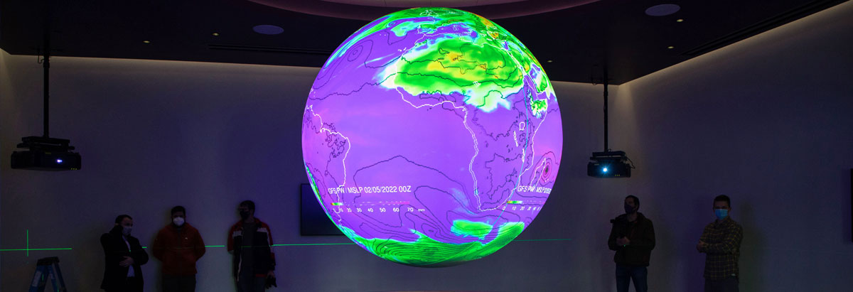 Hologram of earth hovering in a large room with the lights turned off